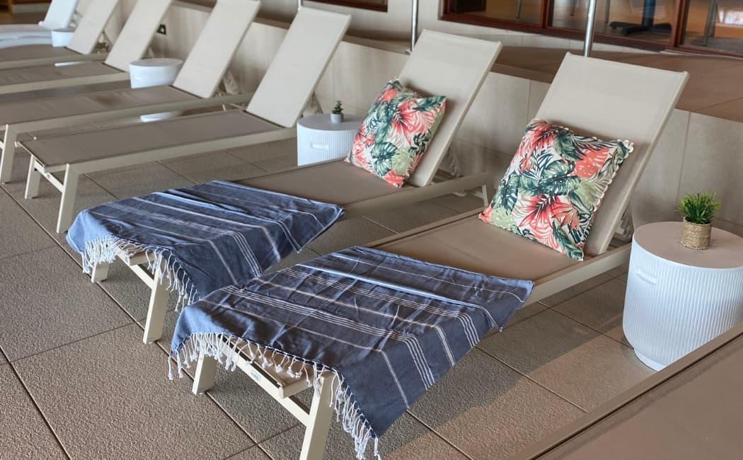 Morgonsol över yogamattorna på terrassen, med ljuslykta och buddhaljus i förgrunden