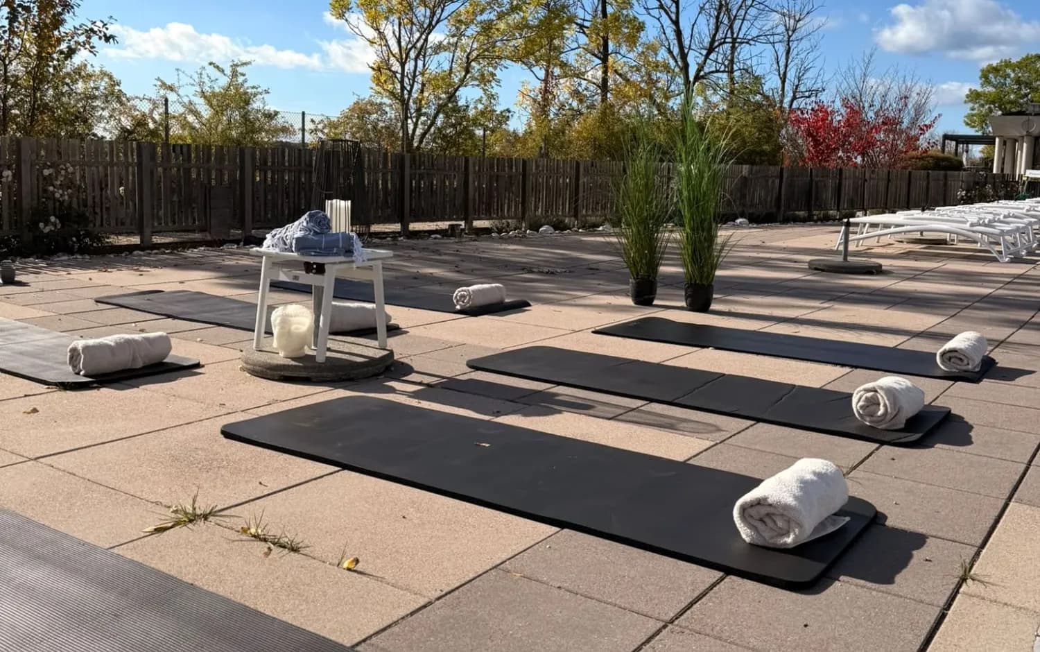 Yogamattor med rullade handdukar på terrassen en solig höstmorgon